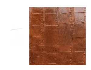 Dettaglio in pelle marrone goffrata coccodrillo con placchetta logo in metallo per borsa