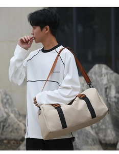 Primer plano del bolso de viaje en lona beige con correas negras y bandolera ajustable