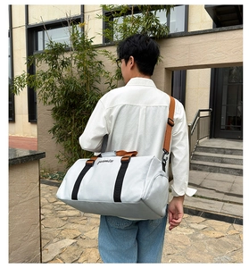 Vista trasera de una bolsa de deporte gris claro con gran capacidad y correas ajustables