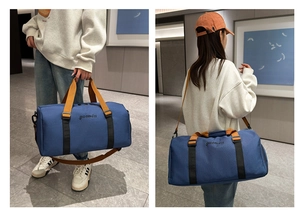 Detalle de bolsa de viaje gran capacidad con correas naranjas y tejido azul marino