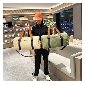 Detalle de bolsas de viaje de lona beige y verde militar con correa ajustable