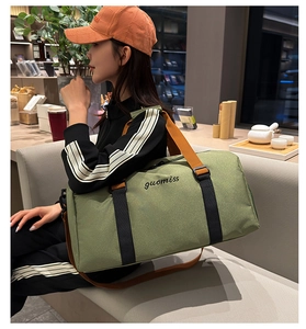 Detalle de la bolsa de viaje verde claro con asas naranjas y rayas decorativas negras