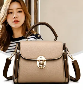 Close-up of beige lychee leather bag featuring a gold round buckle and brown handle