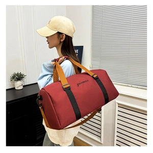 Primer plano de una bolsa de deporte burdeos con correas negras y hebillas laterales