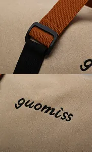 Detail showing the precision stitching, embroidered logo and nylon webbing on the canvas bag