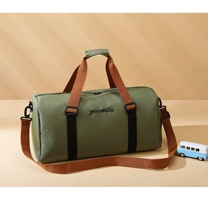 Detail of dark green oxford travel tote with embroidery, brown handles and shoe compartment