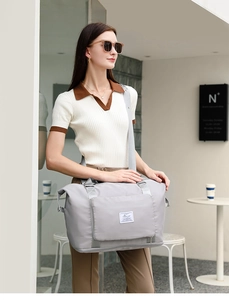 Primer plano de bolsa de viaje de nailon gris claro impermeable con correa ajustable