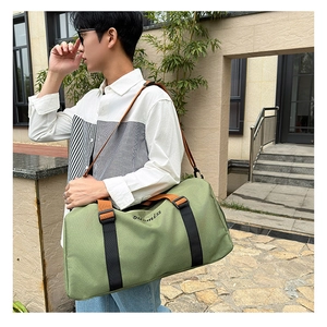 Close-up of green Oxford tote bag with logo embroidery and dual-tone shoulder strap