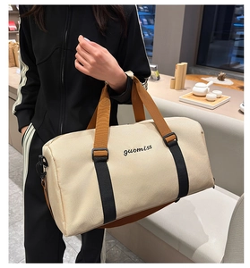 Close-up of beige travel tote bag with brown handles and durable embroidered logo