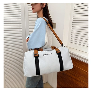 Close-up of the light blue travel tote featuring black embroidered logo and woven strap