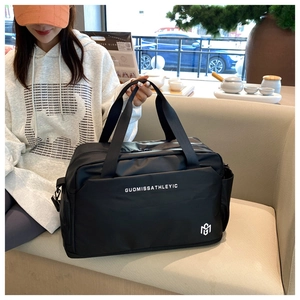 Detalle del bolso de viaje negro impermeable con logo blanco y textura de nailon
