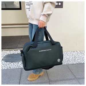 Detalle del bolso tote oxford impermeable verde oscuro con asas reforzadas y logo