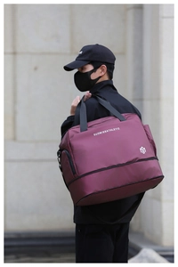 Bolso de viaje impermeable granate con compartimento inferior mostrado en modelo