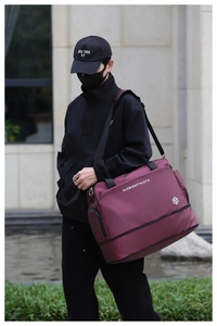 Detalle de la bolsa de viaje burdeos impermeable con correas tejidas y bolsillo con cremallera