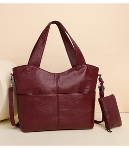 Detail of wine red tote bag set with textured leather and a matching small purse