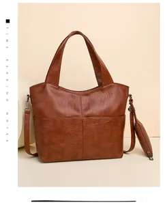 Detail of caramel brown lychee leather tote bag with a small matching zipper pouch