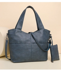 Detail of navy blue pebble leather tote bag with crossbody strap and matching mini pouch