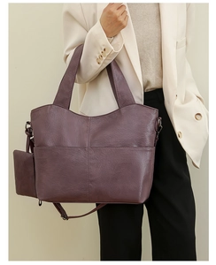 Detail of deep purple faux leather tote bag with cross-stitched pockets and small coin purse