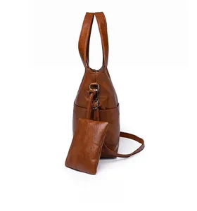 Brown vintage leather tote bag detail with matching mini pouch and adjustable strap
