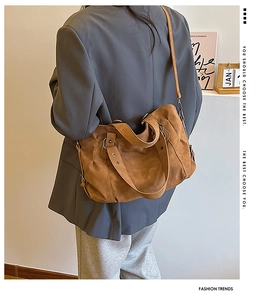 Detail of tan matte tote bag with metal ring accents and adjustable shoulder strap