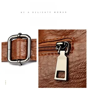 Close-up of metal buckle and zipper detail on brown lychee texture leather handbag