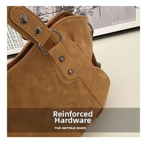 Macro shot of durable silver metal rings and rivets on brown frosted leather tote bag