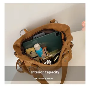 Detailed view of the large capacity interior showing daily items in a matte tote bag