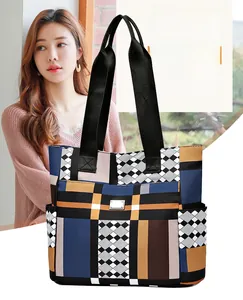 Vista macro di una borsa tote patchwork con motivi geometrici blu, arancio e marrone