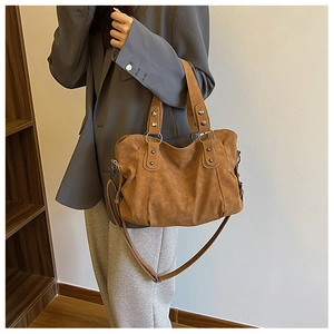 Detail of vintage caramel tote bag with silver studs and soft slouchy faux leather texture