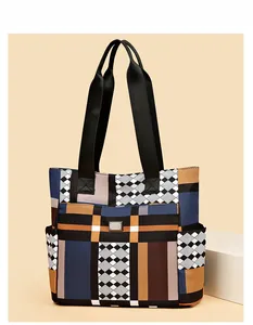 Dettaglio di borsa tote geometrica colorata con manici larghi e tasche laterali