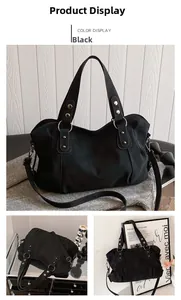 Detail view of large black matte tote bag with silver hardware and adjustable straps