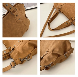 Detailed macro of vintage brown tote bag with silver studs and adjustable leather strap