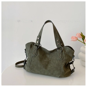 Detail view of dark green retro tote bag with silver studs and metal ring buckle