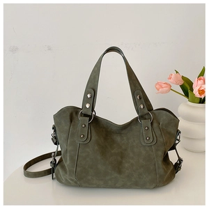 Detail of vintage green tote bag with silver rivets, matte leather, and tulip decor