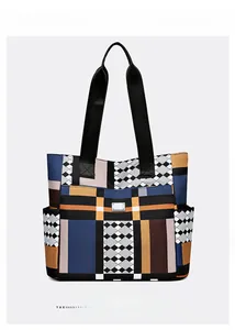 Dettaglio di una borsa geometrica con patchwork blu e arancione e cinturino nero