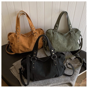 Three minimalist matte leather tote bags in brown, green, and black with metal hardware