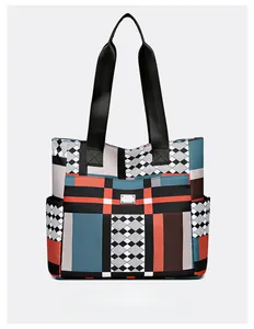 Dettaglio della grande borsa tote con motivo geometrico e placca logo in metallo argentato