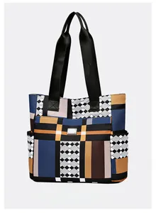 Dettaglio della grande borsa tote patchwork geometrica con tasche laterali e logo metallico