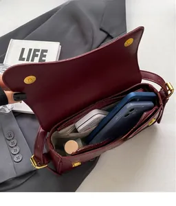 Détail intérieur d'un sac à bandoulière bordeaux motif crocodile et grand espace