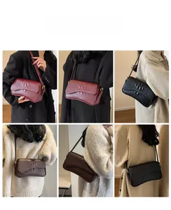 Détail des sacs sous le bras en cuir à motif crocodile en noir, marron et rouge vin