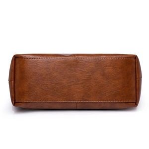 Bottom view of large brown leather tote bag showing reinforced stitching and texture