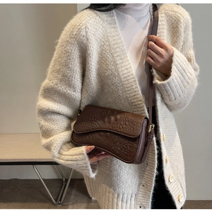 Détail du sac à main marron foncé motif crocodile avec boucle en métal doré élégante