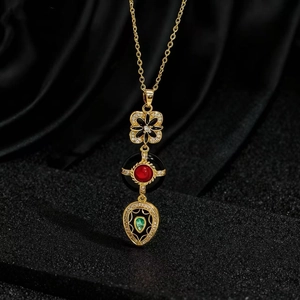 Dettaglio macro della collana vintage dorata con gemme colorate e ciondolo smaltato