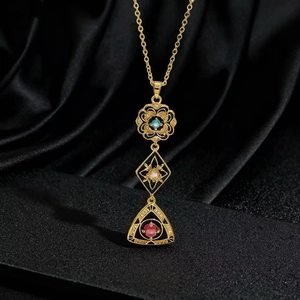 Dettaglio ravvicinato di una collana vintage dorata con pietre preziose colorate
