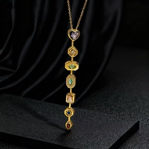 Elegante collana d'oro con pendente in cristallo geometrico colorato su sfondo velluto