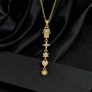 Dettaglio collana dorata con ciondoli hamsa, croce e stelle su seta nera