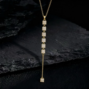 Raffinata collana con nappa in ottone dorato e sette ciondoli quadrati in cristallo zircone