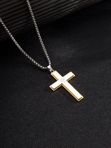 Détail macro d'un pendentif croix bicolore au design superposé argent et doré
