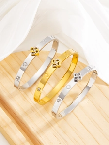 Detailed view of polished four-leaf clover bracelets with sparkling diamond clasp on tray