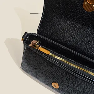Detailed macro view of black pebble leather handbag with gold zipper and magnetic closure